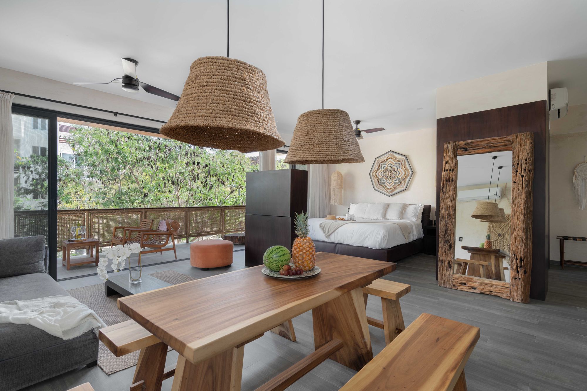 El loft: mesa de madera, cama king y el balc&oacute;n a la selva