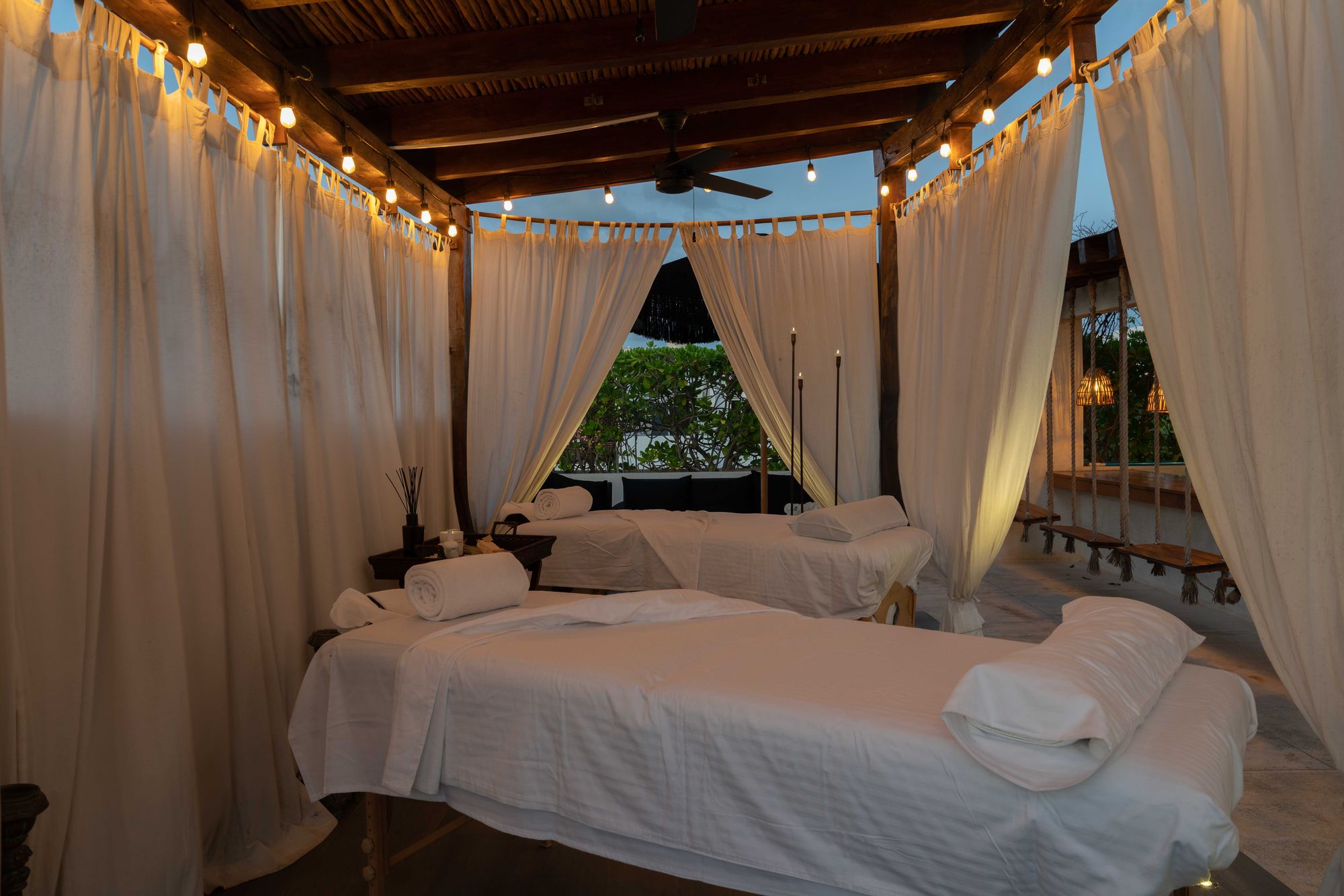 Spa de la azotea con cortinas de lino y luces cálidas